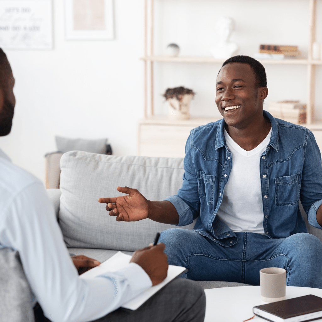 Homme qui échange avec son psychologue en souriant pendant une séance de psychothérapie